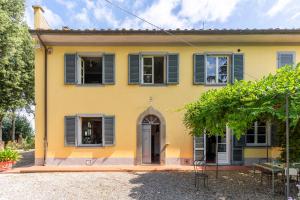 Fattoria Laviosa في Fauglia: منزل أصفر مع مصارع زرقاء
