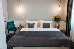 1 dormitorio con 1 cama y 1 silla azul en Hotel Golfi en Poděbrady