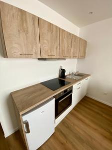 eine Küche mit Holzschränken und einer Arbeitsplatte in der Unterkunft L'échappée belle d'Albi in Albi