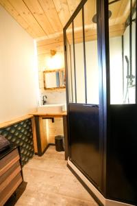 ein Bad mit einer schwarzen Tür in einem Zimmer in der Unterkunft Le petit Repaire de Sailhan, Ecolodges in Sailhan