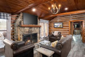 a living room with couches and a stone fireplace at Buckhorn Hideaway By Stony Brook Cabins in Gatlinburg