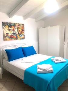 1 dormitorio con 1 cama con sábanas azules y una pintura en Sideroporta castle Náfpaktos, en Nafpaktos