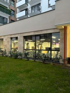 a building with windows and plants in a yard at Mieszkanie z basenem i siłownią Bronowicka in Szczecin