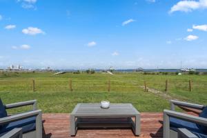 a patio with a table and two chairs and a field at Sunset Vista Beach House in Pensacola Beach
