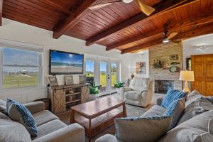a living room with two couches and a tv at Sunset Vista Beach House in Pensacola Beach