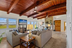 a living room with two couches and a tv at Sunset Vista Beach House in Pensacola Beach +38 photos