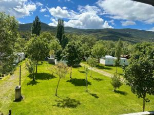 an image of a garden with trees and houses at SOLOPUENT Hotel Rural in Castiello de Jaca