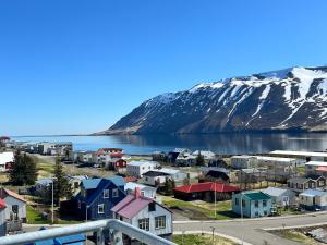 una piccola cittadina vicino a un bacino d'acqua con una montagna di Gagginn Siglo a Siglufjörður