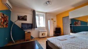 Un dormitorio con una cama y un televisor. en Great Buda Apartman, en Budapest