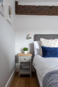 a bedroom with a bed and a nightstand with a plant on it at Luxury Apartment Woodsmill View - on the river - with balcony - Recently refurbished in York