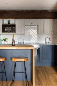 a kitchen with a counter and two stools at Luxury Apartment Woodsmill View - on the river - with balcony - Recently refurbished in York