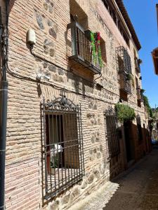 um edifício de tijolos com duas janelas e uma varanda em Casón De Los López Apartments em Toledo