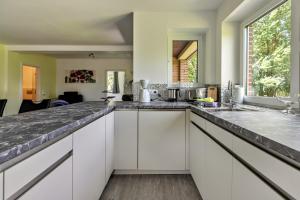 a kitchen with white cabinets and a counter top at Sylt in Galmsbüll
