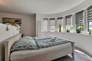 a bed in a bedroom with windows and a bedvisor at Sylt in Galmsbüll