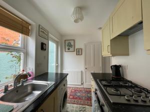 uma cozinha com um lavatório e um fogão em No 28 cosy cottage in the heart of Cowes em Cowes