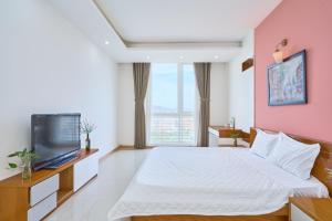 ein Schlafzimmer mit einem großen Bett und einem TV in der Unterkunft Pooh House 6 - Back Beach apartment in Vũng Tàu