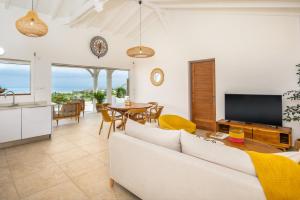 TV a/nebo společenská místnost v ubytování Résidence Les Raisins Clairs - Villas standing 4 étoiles , vue sur mer panoramique & piscine à débordement