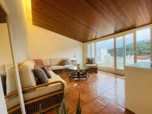 un soggiorno con divano e tavolo di Penthouse on Passeig del Mar de Tamariu Large Terrace Free WiFi Platja a Tamariu