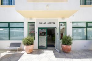 un edificio con un letrero que lee Dumms Hospital en Dunas Hostel & Guesthouse, en Alvor
