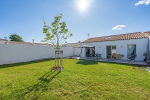a small tree in a yard next to a house at Jolie maison à Saint-palais in Saint-Palais-sur-Mer