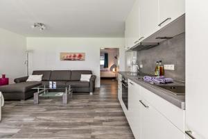 a kitchen and living room with a couch and a table at Amrum in Galmsbüll
