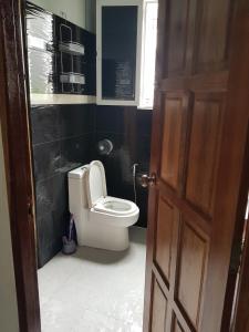 een badkamer met een toilet en een raam en een deur bij BTL Sunny in Bang O