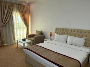 a hotel room with a large bed and a chair at Royal Heaven Hotel Qatar in Doha