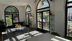 - un salon avec de grandes fenêtres et une table dans l'établissement Ostello di Vicenza, à Vicence