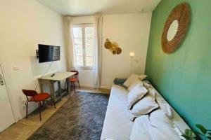 a room with a green wall with a bed and a desk at Le Saint Julien 1 - Basilique in Reims