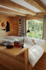 a bedroom with a bed with a desk and a window at Montagne Alternative in Orsières
