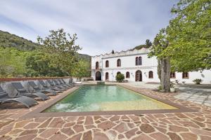 uma propriedade com uma piscina em frente a um edifício em El Cortijo em Arenys de Munt