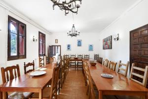 El Cortijo في Arenys de Munt: غرفة طعام كبيرة مع طاولات وكراسي خشبية