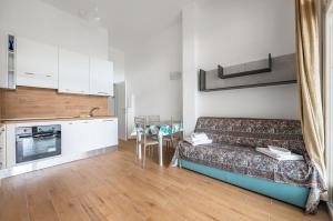 ein Wohnzimmer mit Couch und Küche in der Unterkunft Deiva Marina Sea House! Functional Apartment in Deiva Marina