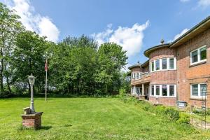 an old brick house with a lawn in front of it at Sylt in Galmsbüll