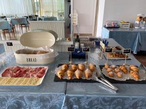 una mesa cubierta con diferentes tipos de bollería y comida en Hotel Ariston, en Sottomarina