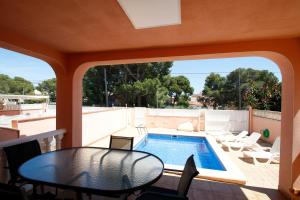 Un patio con una mesa y una piscina. en Villa Fatima, en Miami Platja