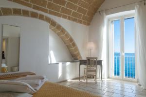 ein Wohnzimmer mit einem Tisch und einem großen Fenster in der Unterkunft B&B Finestra Sul Mare in Gallipoli