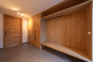 a walk in closet with wooden doors and tile floors at House Natura Savica in Bohinj
