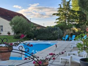 a patio with chairs and a swimming pool with at La Garenne in Virazeil