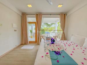 ein Schlafzimmer mit einem Bett mit Blumen darauf in der Unterkunft Lagoon Villa Thoddoo in Thoddoo-Atoll