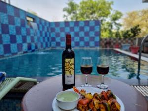 a table with a bottle of wine and a plate of food at Hotel Darbargarh, Udaipur in Udaipur