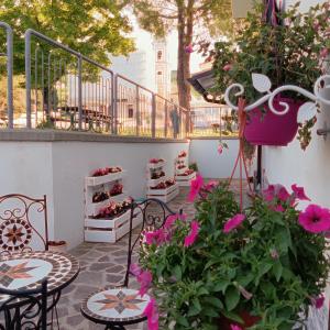 um pátio com flores cor-de-rosa, mesas e cadeiras em B&B COLLE TARIGNI em Manoppello
