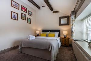 een slaapkamer met een bed met gele kussens bij The Fleece Inn at Barkisland in Ripponden