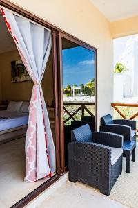 a room with a balcony with a bed and a window at Atenea Holbox in Holbox Island