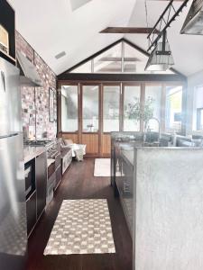 a large kitchen with stainless steel appliances and wood floors at T h e L o f t - Stunning private apartment in Perth