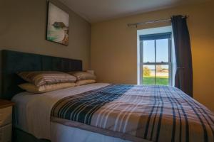 una camera da letto con un letto e una finestra di Carrig Island Lodge a Ballylongford