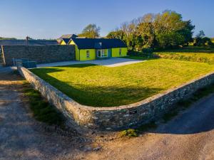 a stone retaining wall in front of a house at Carrig Island Lodge in Ballylongford