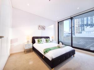 a bedroom with a bed and a large window at Cozy Apartment at St Leonard in Sydney