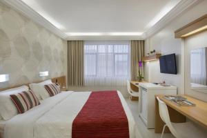 リオデジャネイロにあるコパ スウ ホテルの大きなベッドとデスクが備わるホテルルームです。