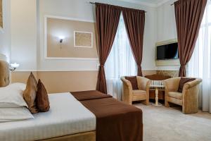 a hotel room with a bed and a chair at La Strada Boutique Villa in Piteşti